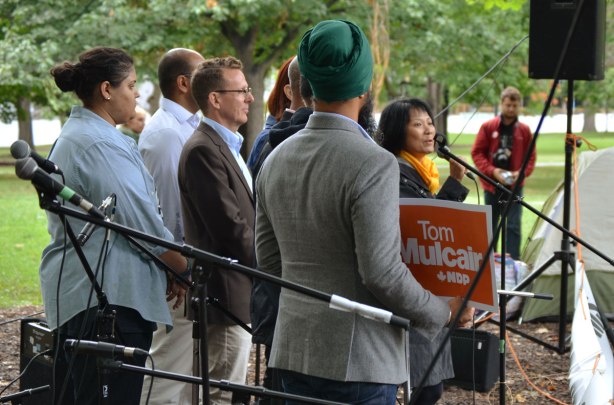 A group of NDP candidates from the GTA including Andrew Cash, Peggy Nash, Akil Sadikali, and Jennifer Hollett,are standing together. Olivia Chow is addressing the small crowd that has come to the rally to repeal Bill C 51. One of the candidates is holding a Tom Mulcair sign.