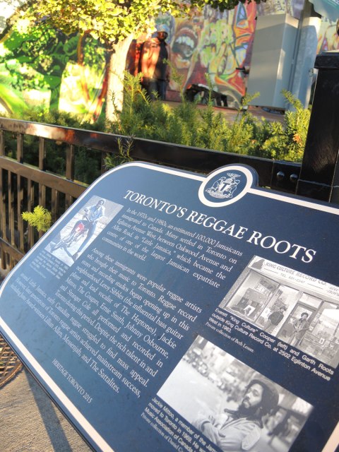 plaque with the title "Toronto's Reggae Roots" with three photos as well as a story of Jamaican immigrants to Toronto and the story of reggae music in Toronto