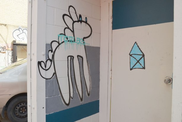 line drawing of a dinosaur on a wall beside a door. 