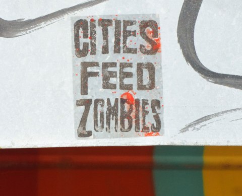 a stenciled sign that says Citied Feed Zombies