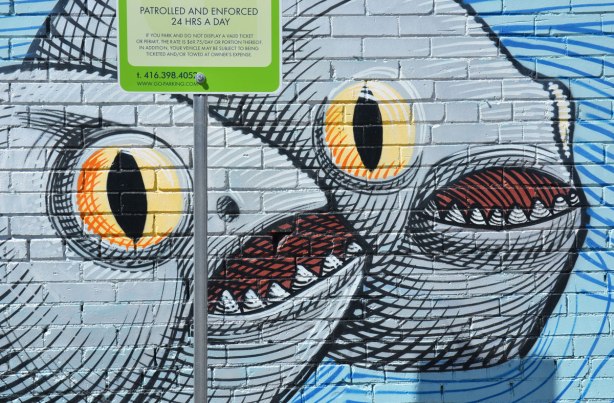 two big round grey fish with open mouths and big yellow eyes, part of a larger mural 