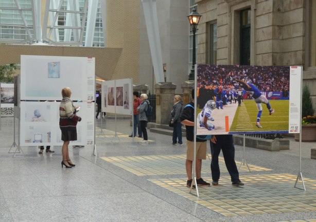 people looking at photographs, the winning pictures from the World Press Photo contest, on display at Brookfield Place 