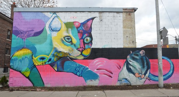 large mural of a cat chasing a mouse done in bright colours. 