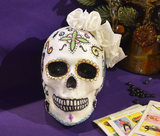 skull painted white and then decorated with black, green, red and white