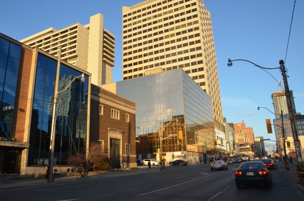 looking east along Eglinton Avenue towards Yonge street with Duplex Ave in the foreground. The old Toronto Hydro-Electric building is in the picture, with a newer structure with a glass front beside it. New buildings between Duplex and Yonge on the north side of Eglinton are also in the picture.