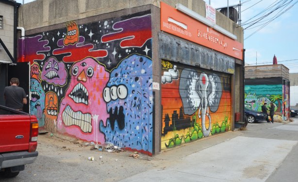 garages and walls at the back of stores and restaurants covered with street art. Pink anf purple blob like creatures and an elephant