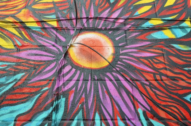 Detail of a flower from a largeer street art piece. It looks like a purple and red daisy