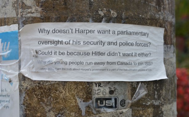 small paper taped to a hydro pole on a residential street. On the paper are typed the words: WHy doesn't Harper want a parliamentary oversight of his security and police forces? Could it be because Hitler didn't want it either? Why do young people run away from Canada to join ISIS?