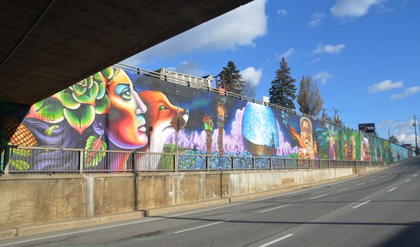 looking eastward along a long horizontal mural painted beside a city street