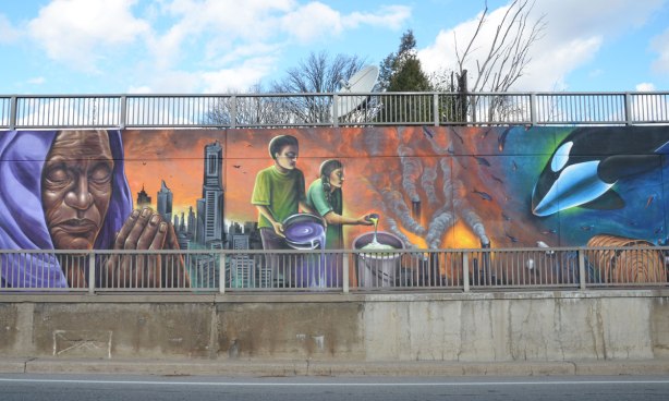 mural with people, city life and comment on mistreatment of the environment