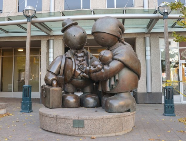 Immigrant Family, a sculpture by Tom Otterness, a father mother and baby in arms.