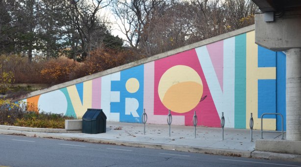 part of a mural on an underpass. There are four parts to the mural and each part is word painted in large capital letters in many colours - the word love, actually it is love or love