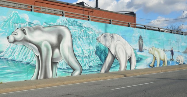 arctic scenes as part of a larger street art mural on an underpass in Toronto - polar bears walking on ice, with an iceberg behind them.