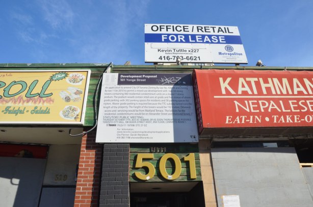 development proposal sign above a large number 501, with an office/retail for lease sign above it. 