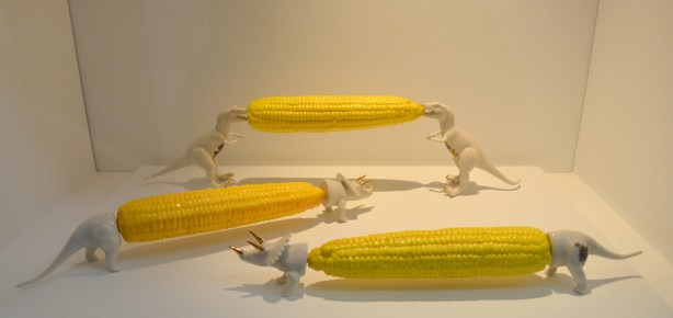 sculptures of cobs of corn, three, each with dinosaur corn cob holders. 