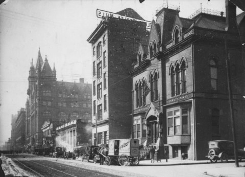 historical picture of Richmond Street near Berti, taken in 1922, old buildings, a, horse drawn cart and an old car. Streets but no traffic. black and white photo.