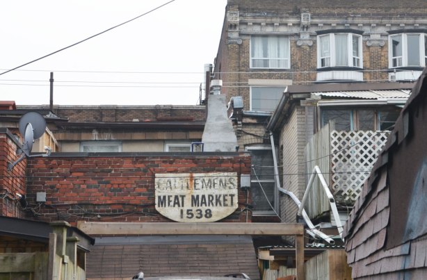old sign on the back of a building that says Cattlemens meat market 1538