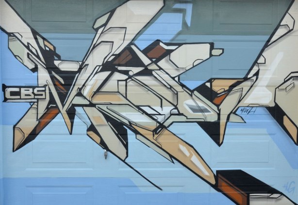 CBS mediah geometric spray paint pience on a garage door. 