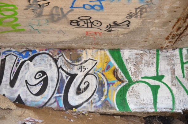 graffiti under a raised parking lot 