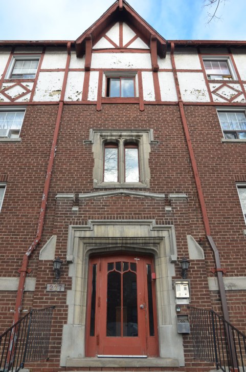front door and front of building, four storey apartment building in red brick with stone window and door frames. 