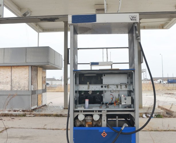 old unused fuel pump with blue panel on the bottom but panel covering on the middle section is missing exposing the wiring and innards of the pump