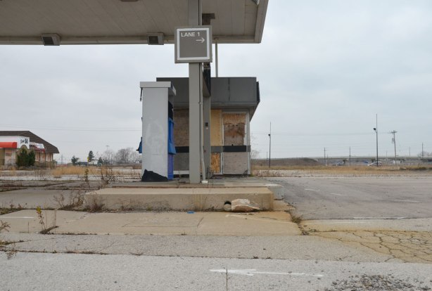 lane 1 sign above an abandoned gas station