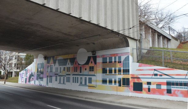 part of a mural by Rob Matejka and Tommy Matejka on the wall on a TTC subway underpass at Keele, a mural of houses on a street