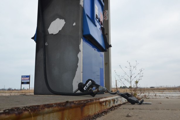 an old abandoned fuel pump at Stop 50 gas bar. The nozzles and hoses are pulled out and on the ground. 