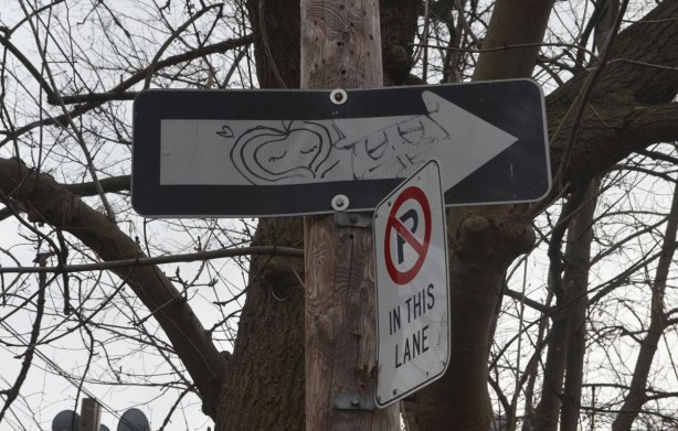 Two faces drawn on a one way sign