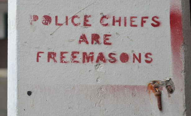 stencils on concrete, in red, words that say: Police Chiefs are Freemasons