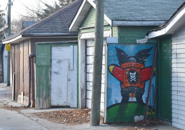 man-like shaped rocket on a wall, red wings outstretched, cat skull motif on the front 
