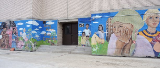 mural across the lower level of a high rise building, surrounding an entranceway