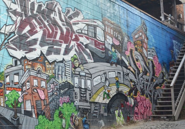 mural on the side of building in an alley, TTC streetcar, buildings, people, subway,