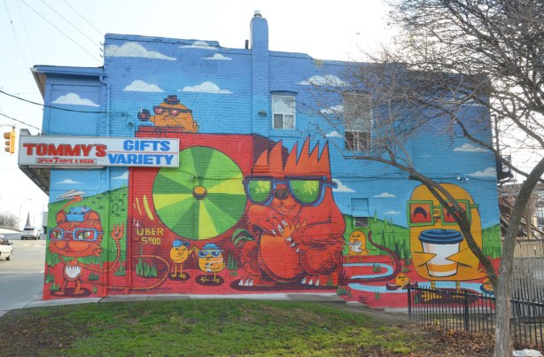 Uber5000 mural on the side of Tommys Gift and Variety store on Dundas WEst. Uber birdie with a white coffee cup, cat listening to a giant CD player
