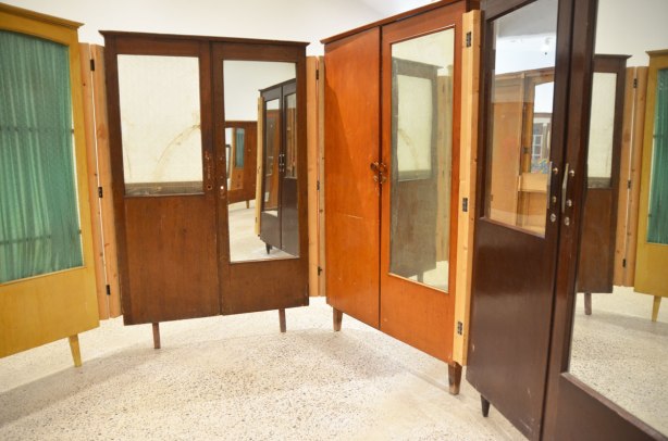 part of an art installation by Chinese artist Song Dong using vintage wooden wardrobe doors with mirrors and curtains, reflections