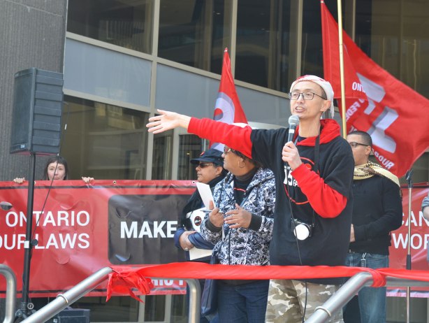 photographs taken at a rally and protest in support of a $15 minimum wage, The Fight for 15 and fairness - one of the leaders, a young Asian man, gives a speech