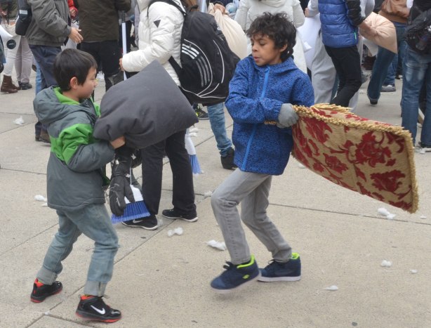 two young boys swing pillows at each other - people in the midst of a large pillow fight at Nathan Phillips square in celebration of international pillow fight day - 