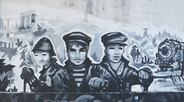 mural in black, white, and grey about the first railway in Ontario, 1853, that was built here, and where the railway still runs as the GO line to Aurora - three railway workers in jackets and caps