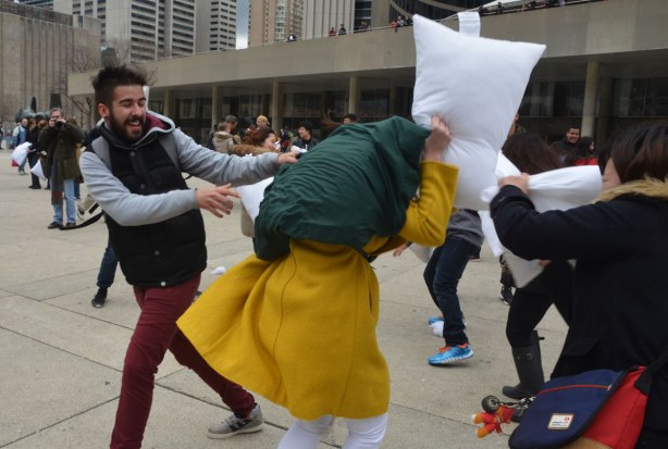 young people participating in a large outdoor pillow fight