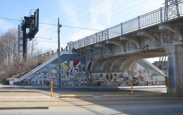 mural on a railway bridge underpass that has a soccer theme. Flags of different countries, soccer players, words, 