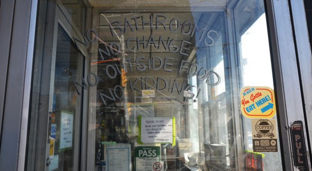 The painted sign on the door of Dangerous Dan's restaurant that says, No bathrooms, no change, no outside food, no kidding.