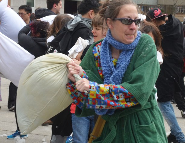 people in the midst of a large pillow fight at Nathan Phillips square in celebration of international pillow fight day - 