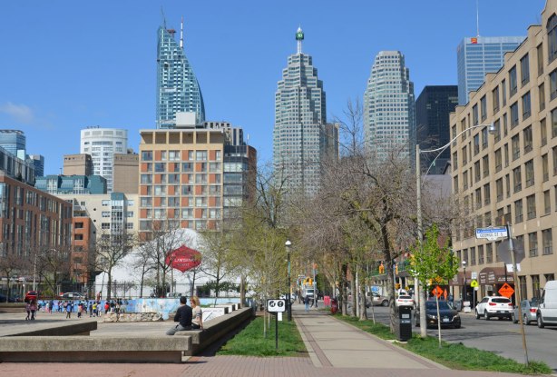 at the corner of The Esplanade and George Street, looking west towards downtown and St. Lawrence market. Playground on the left with children playing. 