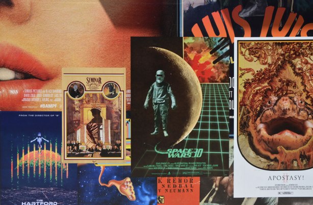 detail of an art installation that is a wall of fake movie posters made with ads and illustrations from old books and magazines