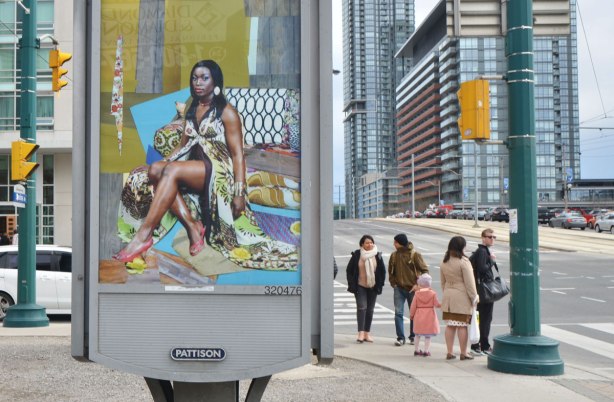 part of an art installation, portrait of a black woman on a billboard, by Mickalene Thomas, in a parking lot in downtown Toronto, A group of people wait for a green light at the intersection in the background, tall condos too. 