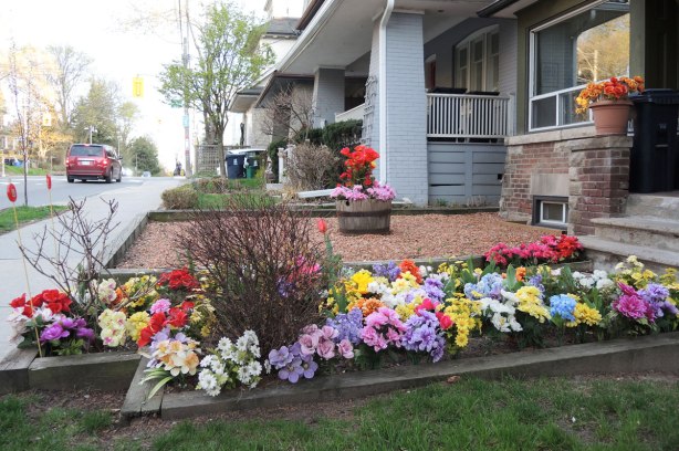 a garden full of fake flowers, colourful plastic flowers instead of real flowers. 