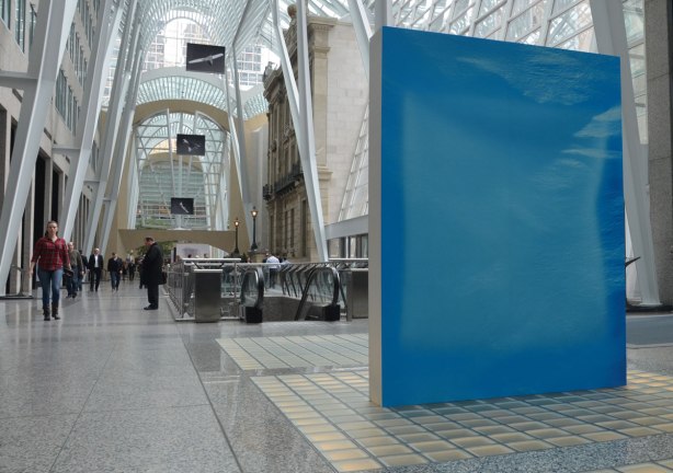 A picture taken inside the Allan Lambert Gallery at Brookfield Place, photos by Sjoerd Knibbeler, a series called Current Study large pictures standing in the middle of the gallery, as well as series called "Paper Planes" which are hung from the ceiling
