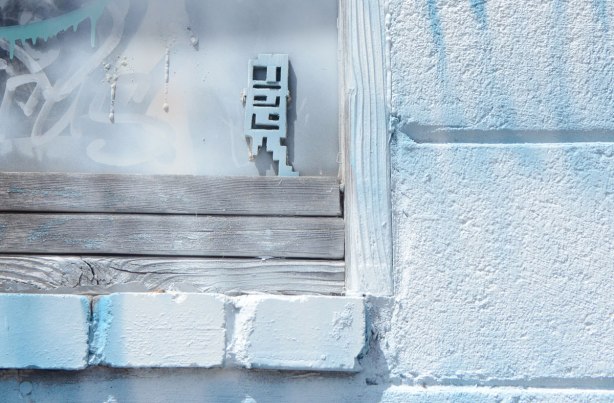 a very pale blue stikman on a very pale blue window and wall. 
