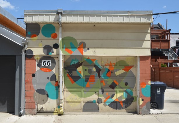 number 66 in a lane, garage door, door and walls covered with circles and triangles in different colours. 