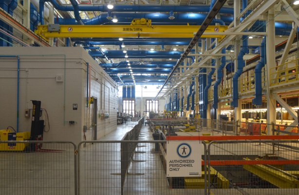 interior of Leslie Barns streetcar facility, a large, tall interior space with lots of pipes 